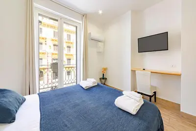 a bedroom with a large bed and a large window at La Ciconella in Palermo