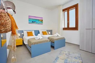 a bedroom with two beds and a window at Villa Etesiae in Castellammare del Golfo