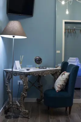 a table and a chair with a desk and a lamp at Casa del Capo in Palermo