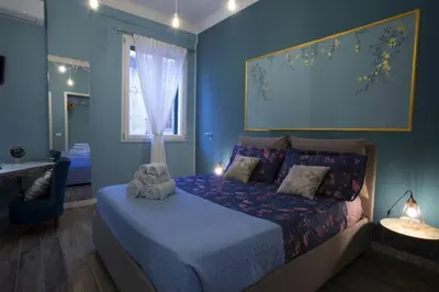 a bedroom with a bed with a blue wall at Casa del Capo in Palermo