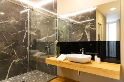 a bathroom with a sink and a glass shower at Divisi Suites & SPA in Palermo
