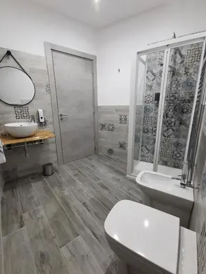 a bathroom with a shower and a toilet and a sink at La Piccola Formica Charme Rooms in Palermo