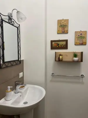 a bathroom with a white sink and a mirror at Le stanze di Ruggero in Palermo