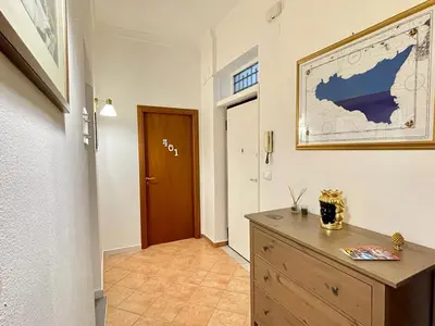 a hallway with a wooden dresser and a door at Le stanze di Ruggero in Palermo