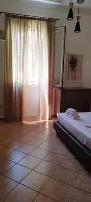 a bedroom with a bed and a large window at Le stanze di Ruggero in Palermo