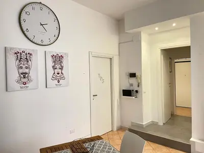 a white room with a clock on the wall at Le stanze di Ruggero in Palermo