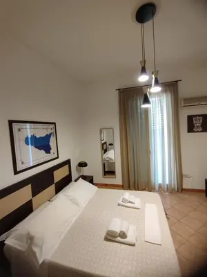 a bedroom with a bed with two towels on it at Le stanze di Ruggero in Palermo