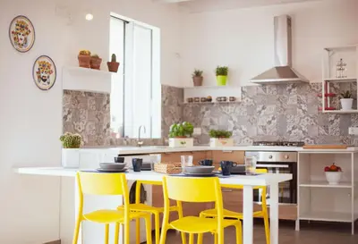 a kitchen with yellow chairs and a white table at Case Playa Resort in Balestrate