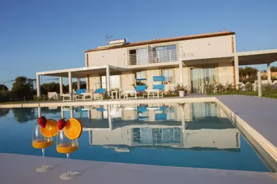 a house with a swimming pool in front of a house at Case Playa Resort in Balestrate