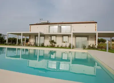 a house with a swimming pool in front of it at Case Playa Resort in Balestrate