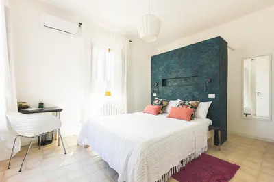 a bedroom with a large white bed with red pillows at Casa Villea in Trabia