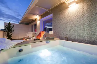 a bathroom with a tub filled with blue water at Miceli Exclusive Suite in Palermo