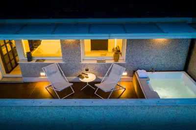 a pool with two chairs and a table and a tub at Miceli Exclusive Suite in Palermo