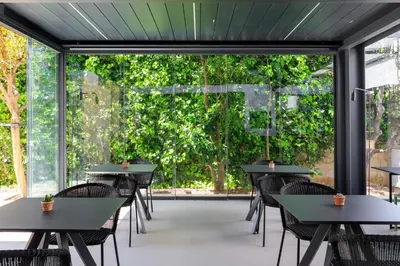 a cafeteria with tables and chairs and a large window at Domìa Boutique Hotel e Cucina in Mondello