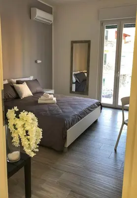 a bedroom with a large bed and a table with flowers at La Casa Di Amalia in Palermo