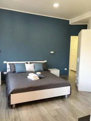 a bedroom with a large bed with a blue wall at La Casa Di Amalia in Palermo