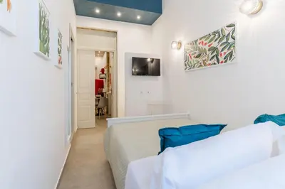 two beds in a room with white walls at Mama Tita Rooms and Breakfast in Palermo