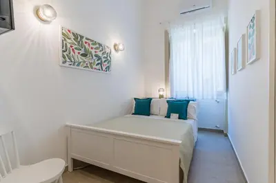 a small bedroom with a bed and a window at Mama Tita Rooms and Breakfast in Palermo