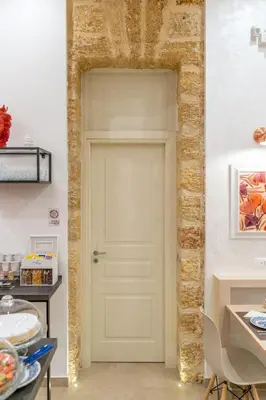 a white door in a room with a brick wall at Mama Tita Rooms and Breakfast in Palermo