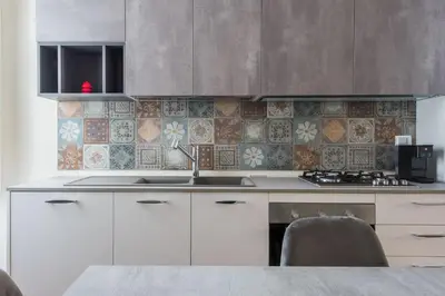 a kitchen with white cabinets and a sink and tiles at Anna's Luxury Apartment in Palermo