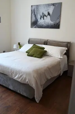 a bedroom with a bed with white sheets and green pillows at Anna's Luxury Apartment in Palermo