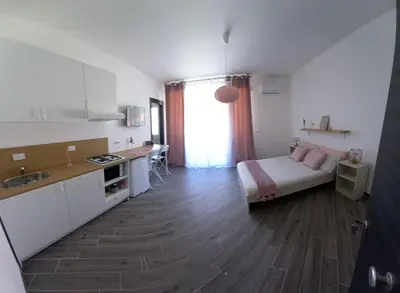 a room with a bed and a kitchen with a sink at DIMENTICA IL CERVELLO in Palermo
