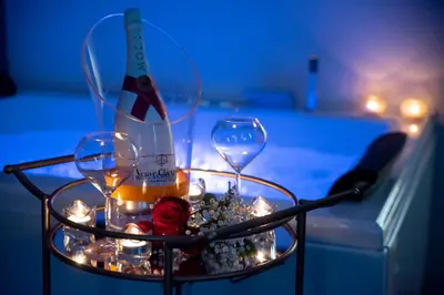 a bottle of wine and two wine glasses on a table at Fervore Luxury Rooms in Palermo