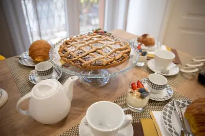 a table with a pie on a table with cups and teapots at Fervore Luxury Rooms in Palermo