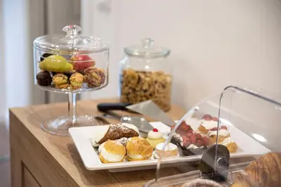 a table with a plate of food and two glass containers at Fervore Luxury Rooms in Palermo