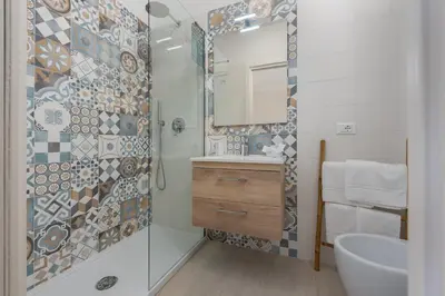 a bathroom with a shower and a sink and a mirror at Scrusciu du mari in San Vito lo Capo