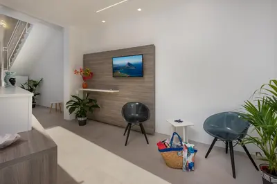 a living room with two chairs and a tv on a wall at Scrusciu du mari in San Vito lo Capo