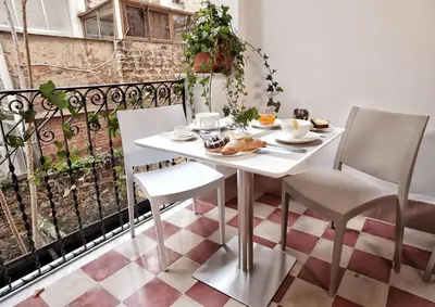 a white table and chairs on a balcony at Ai Quartieri in Palermo