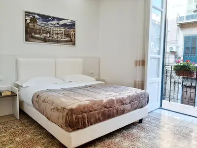 a bedroom with a bed and a large window at Ai Quartieri in Palermo