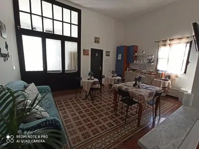 a living room with tables and chairs and windows at Stanze Di Leo in Palermo