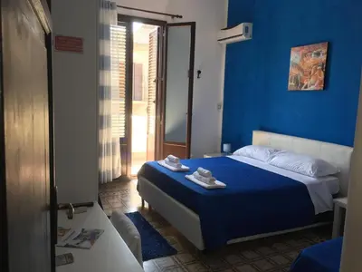 a blue bedroom with a bed with towels on it at Stanze Di Leo in Palermo
