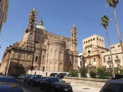 a large building with cars parked in front of it at Stanze Di Leo in Palermo
