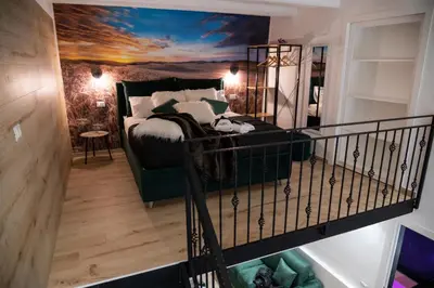 a bedroom with a bed and a staircase with a mirror at La Casa di Lilù in Palermo