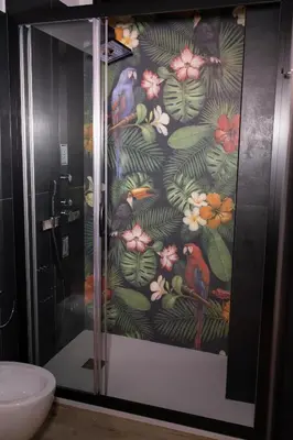 a shower with a wallpaper of birds and flowers at La Casa di Lilù in Palermo