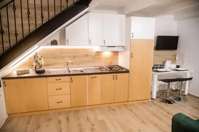 a kitchen with white cabinets and a sink and a staircase at La Casa di Lilù in Palermo
