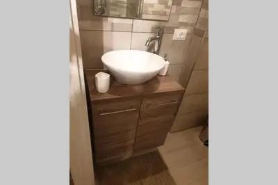 a bathroom with a white sink on a wooden cabinet at Appartamento VITTORIA in Palermo