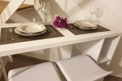 a white table with two plates and wine glasses at Appartamento VITTORIA in Palermo
