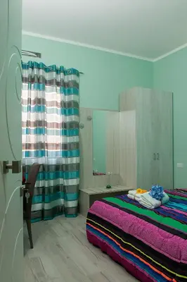 a bedroom with a bed and a shower curtain at B&B Rainbow in Campofelice di Roccella