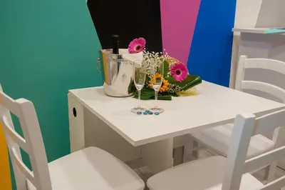 a white table with flowers and a bucket on it at B&B Rainbow in Campofelice di Roccella