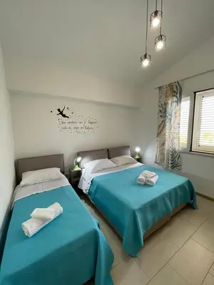 two beds in a bedroom with blue sheets at Casa vacanza 