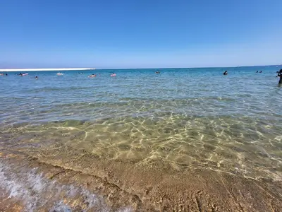 a beach with people swimming in the water at Casa vacanza 