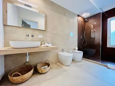a bathroom with a sink and a toilet and a mirror at Curina Luxury Villa - Panoramic Pool Villa near Scopello in Castellammare del Golfo