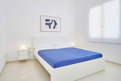 a white bedroom with a bed and a picture on the wall at VILLA DARDA con piscina e 3 camere da letto in Alcamo