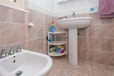 a bathroom with a sink and a toilet and a white sink at Villa Panorama in Cefalù