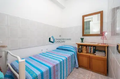 a bedroom with a bed with a striped blanket and a mirror at Villa Panorama in Cefalù