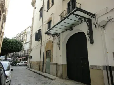 a building with a black door and a balcony at Appartamento in centro Titi's place in Palermo
